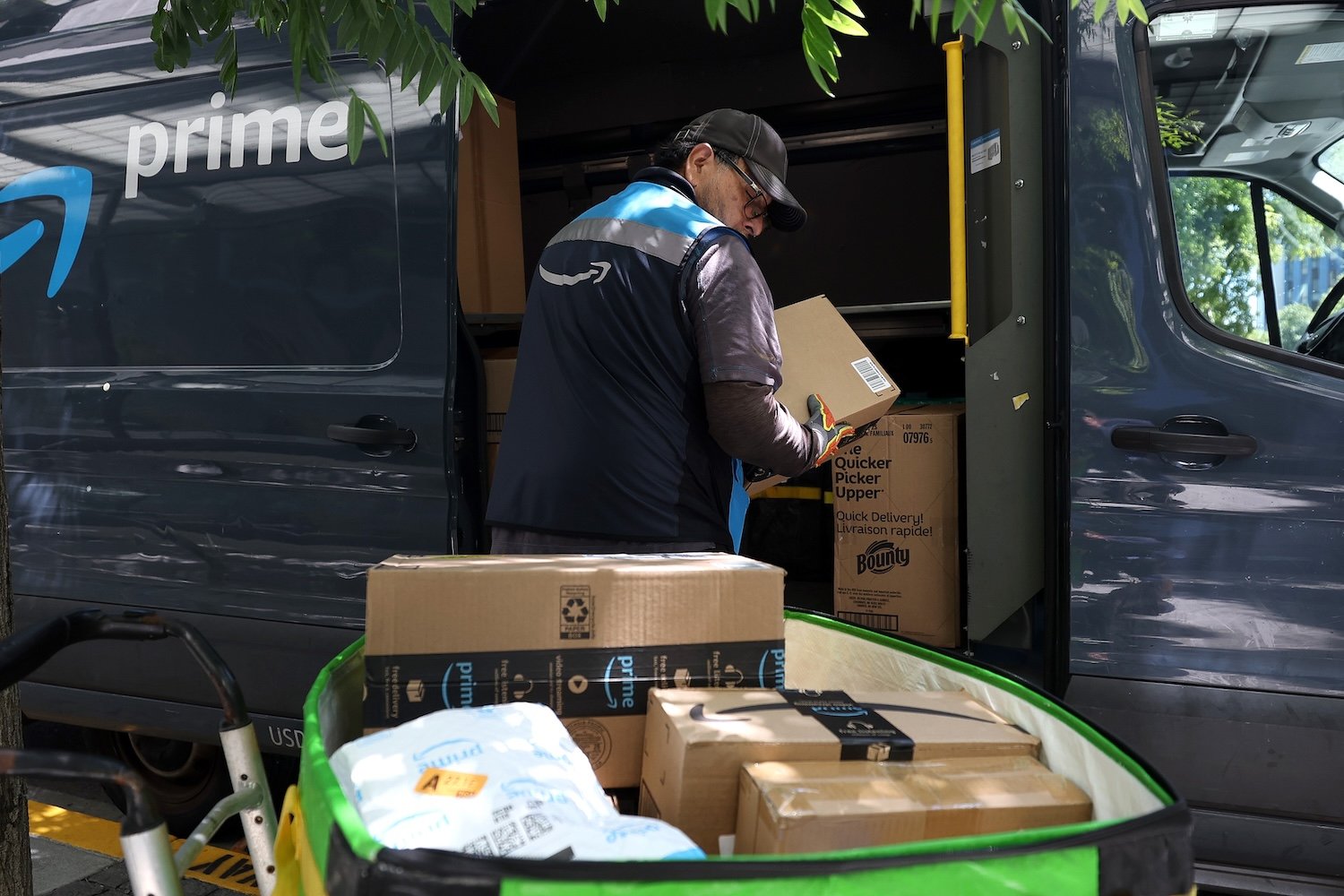 SAN FRANCISCO, CALIFORNIA - JULY 16: An Amazon delivery driver loads a cart with packages on July 16, 2024 in San Francisco, California. As the annual Amazon Prime Day is underway, the U.S. Senate’s Health, Education, Labor and Pensions (HELP) Committee has made public early results of an investigation into working conditions at Amazon warehouses that reveal that Prime Day is a major cause of worker injuries. The committee received internal data from Amazon that showed total injuries on Prime Day 2019 were nearly 45 injuries per 100 workers. Photo: Justin Sullivan/Getty Images