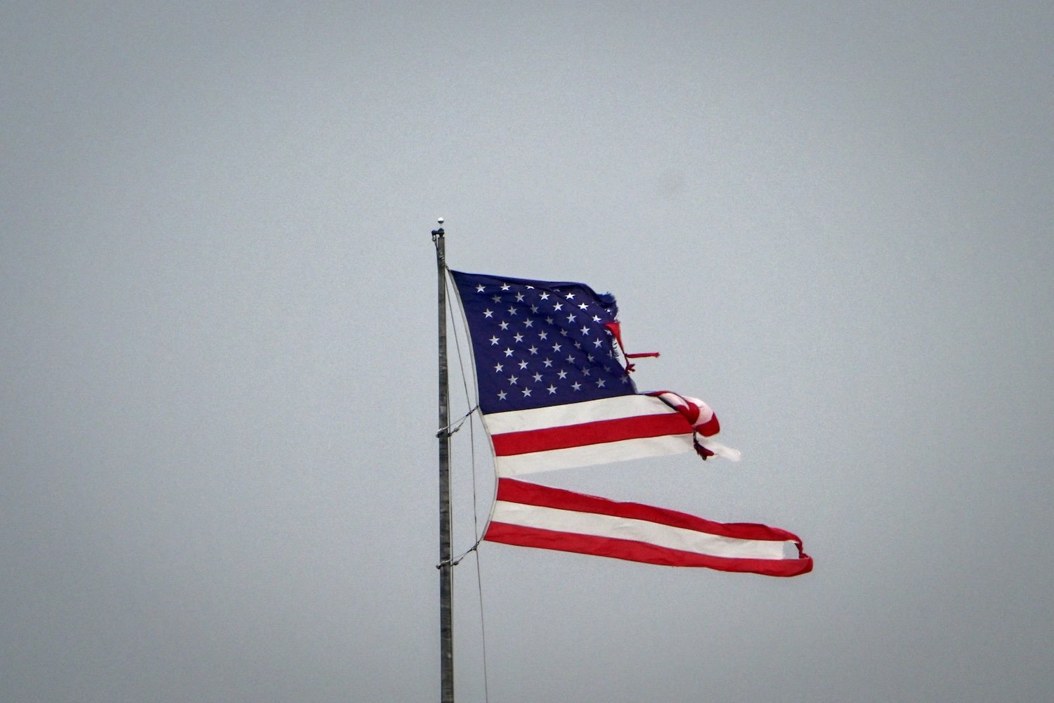 An American flag flies, destroyed by the intense tornado that hit Cocoa Beach, Florida on October 10, 2024. Hurricane Milton tore a coast-to-coast path of destruction across the US state of Florida, whipping up a spate of deadly tornadoes that left at least four people dead, but avoiding the catastrophic devastation officials had feared. (Photo by Giorgio VIERA / AFP) (Photo by GIORGIO VIERA/AFP via Getty Images)