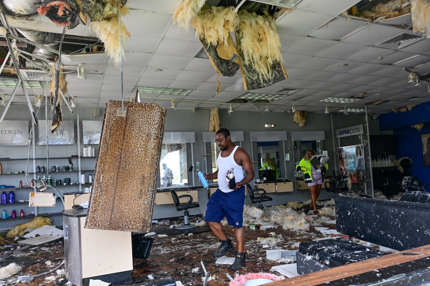 Employees collect some of their belongings from a beauty salon that was destroyed by the intense tornado that hit Cocoa Beach, Florida, on October 10, 2024. Hurricane Milton tore a coast-to-coast path of destruction across the US state of Florida, whipping up a spate of deadly tornadoes that left at least four people dead, but avoiding the catastrophic devastation officials had feared. (Photo by GIORGIO VIERA / AFP) (Photo by GIORGIO VIERA/AFP via Getty Images)