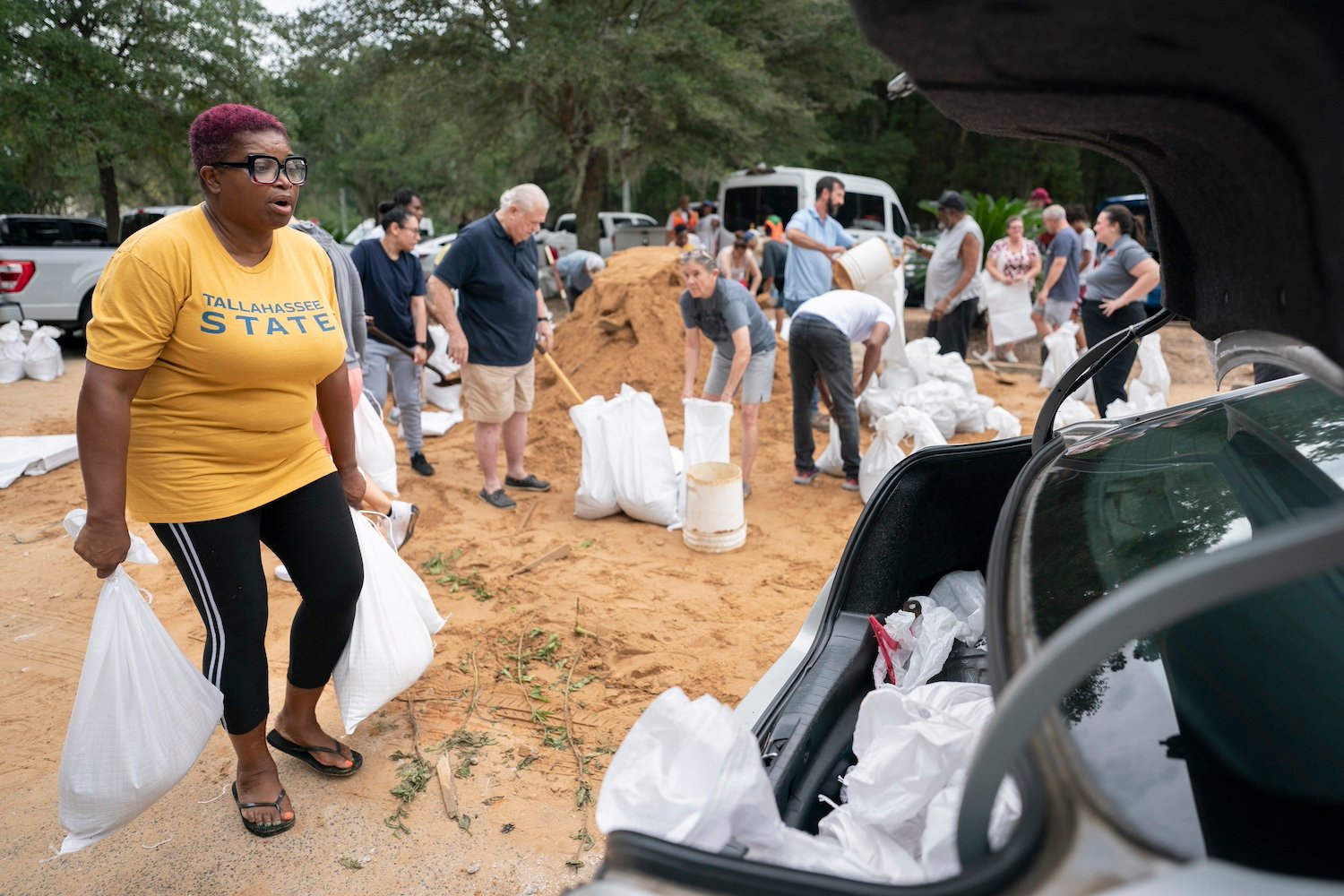 Tallahassee State professor Pamela Andrews carriers sand bags to a car in preparation for possible flooding as Tropical Storm Helene heads toward the state's Gulf Coast in Tallahassee, Florida.